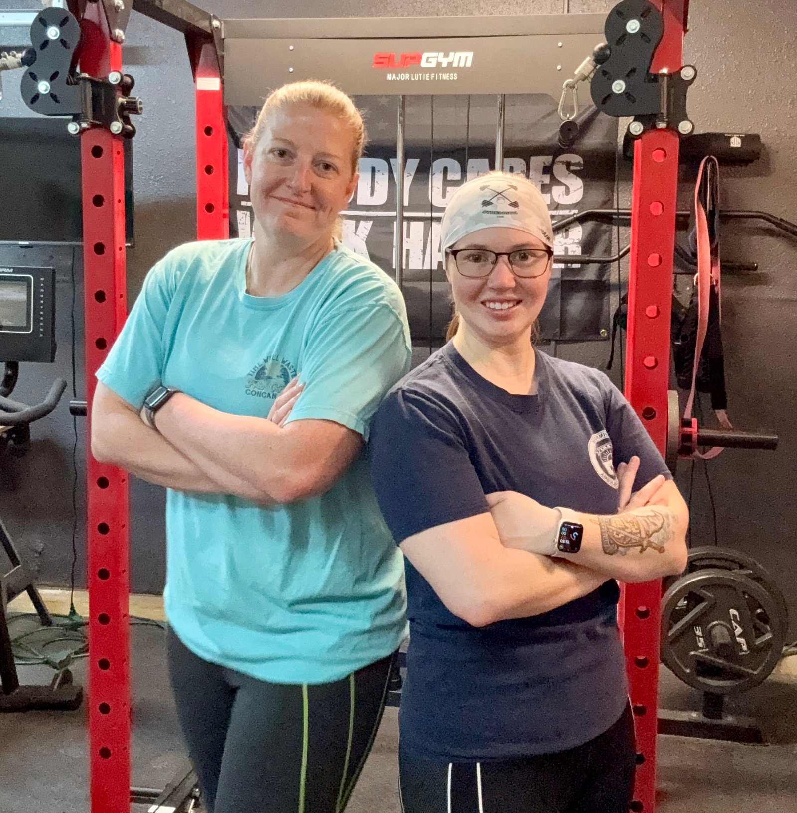 Two women paramedic coaches smiling, EMS fitness coaching experts guiding paramedic fitness program